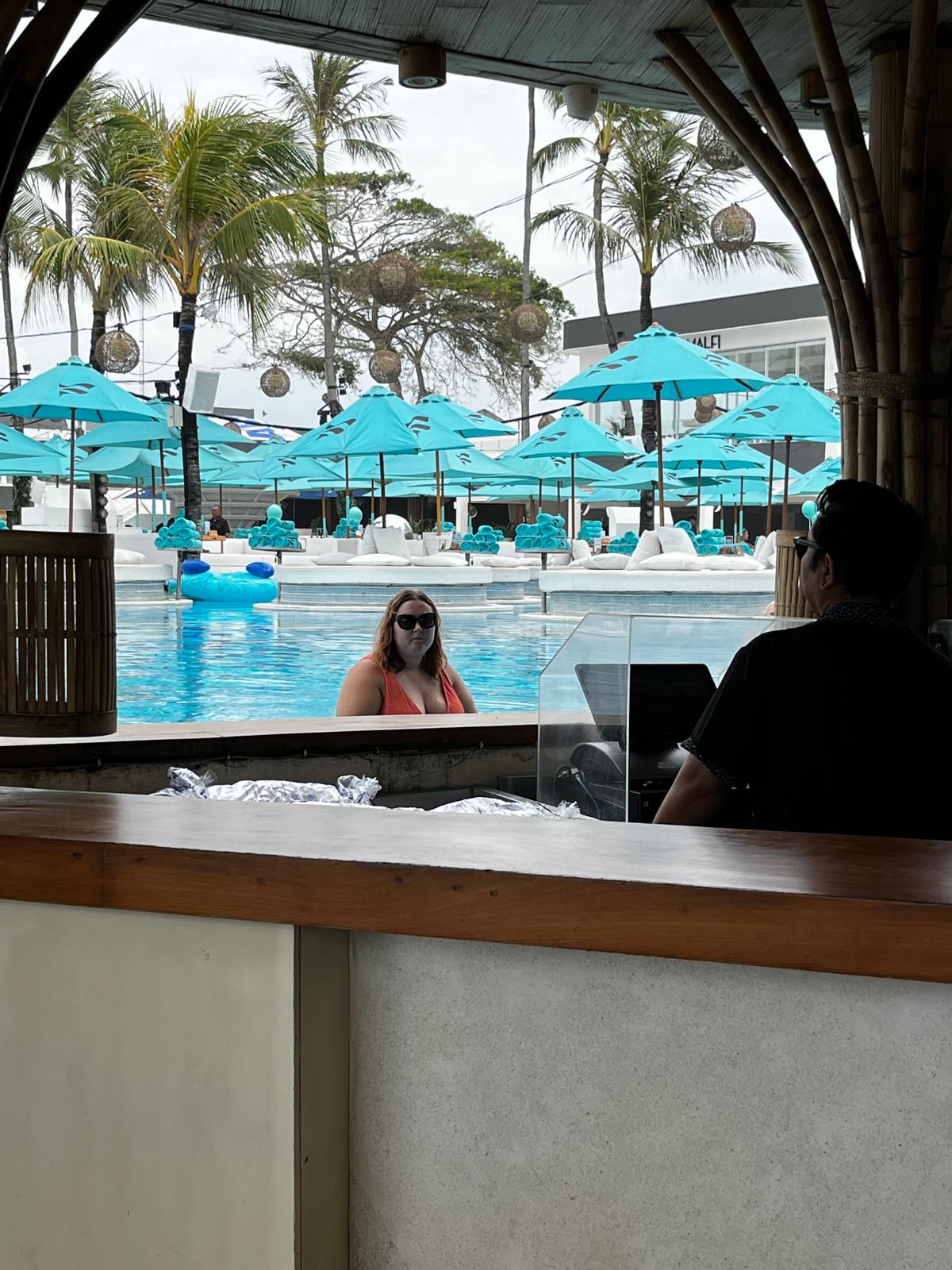 Beach club pool view with turquoise umbrellas in Bali